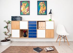 A living room with plants, pictures, and furniture