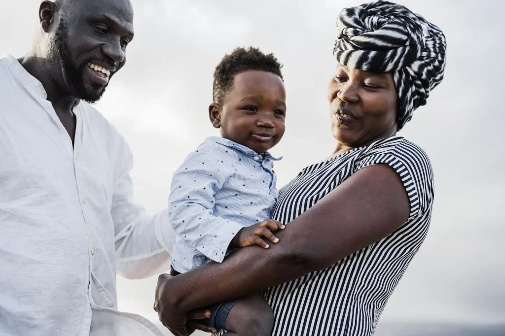 An African boy held by his parents